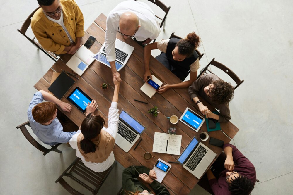 Équipe e-commerce en réunion autour d’un écran et de tableaux de suivi